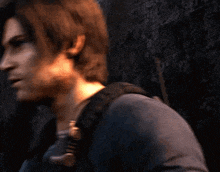 a man with long brown hair is wearing a blue shirt and a backpack .