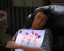 a man is sleeping in a chair while holding a poster that says kpop on it