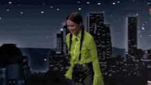 a woman in a neon green shirt and black skirt is dancing in front of a sign that says hollywood
