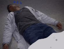 a man in a lab coat laying on the floor with zzz written on his face