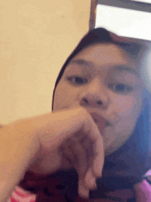 a close up of a woman 's face with her hand on her chin .
