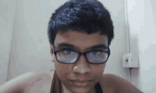 a young man wearing glasses and a red tank top