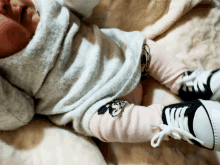 a baby wearing a sweater and socks with a mickey mouse on them