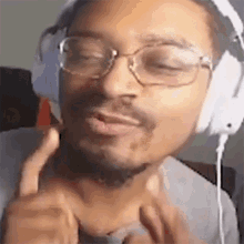 a man wearing headphones and glasses is making a face .