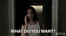 a woman is talking on a cell phone and says what do you want netflix