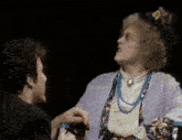 a man and a woman are standing next to each other in a dark room .