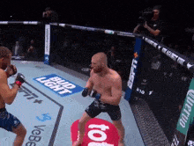 two men are fighting in a boxing ring with bud light and espn on the walls