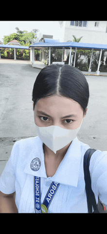 a woman wearing a mask and a lanyard that says " aroba "