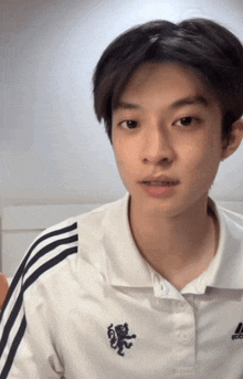 a young man wears a white adidas shirt