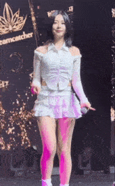 a woman in a white dress is dancing on a stage in front of a dreamcatcher logo .