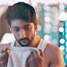a shirtless man with a beard is holding a piece of paper