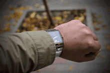 a man wearing a fossil watch looks at the time