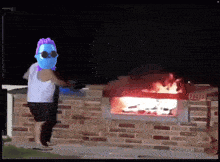 a man wearing sunglasses is standing in front of a brick fireplace