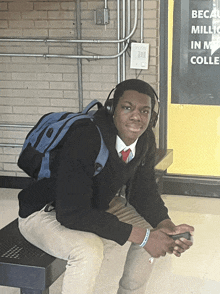 a man wearing headphones sits on a bench in front of a sign that says becau miller in a colleg