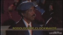 a man in a suit and tie is smoking a cigarette and the words rodolfo the clockmaker are on the screen