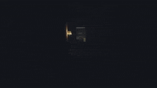 a dark room with a lamp and a person sitting in a chair