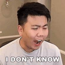 a young man is making a funny face and saying i don 't know .