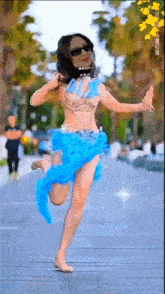 a woman wearing sunglasses and a blue dress is dancing