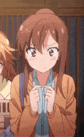 a girl in a brown jacket is making a funny face with her hands folded .