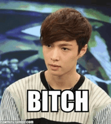 a young man wearing a striped shirt with the word bitch written on it
