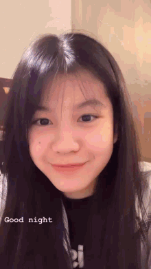 a girl with long black hair is smiling and the words good night are below her