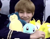 a young man is holding a stuffed animal in his arms .