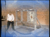 a man is standing in front of a glass wall with a bullet hole in it