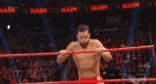 a couple of men are wrestling in a ring on a tv show .