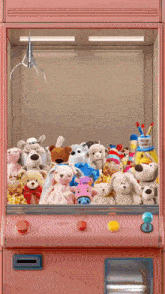 a pink claw machine filled with stuffed animals including a stuffed cow