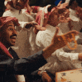 a group of men are playing a board game and one man is holding a pizza
