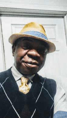 a man wearing a hat and vest is smiling