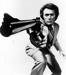 a man in a suit is pointing a gun at the camera .