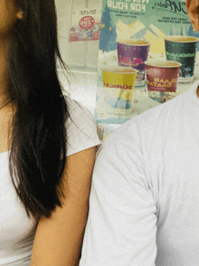 a man and a woman standing next to each other in front of a sign that says ' aaaju ' on it