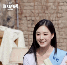 a woman is smiling and wearing a sash that says triples on it