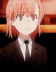 a girl in a suit and tie is looking at the camera