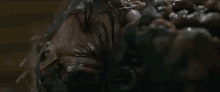 a close up of a person 's face covered in a thick , sticky substance in a dark room .