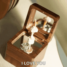a wooden box with a ballerina inside of it and the words " i love you " on the bottom