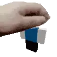 a close up of a person 's hand holding a blue , white and black block .