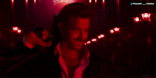 a man in a suit is holding a gun in a dark room with the words pranay and varma above him