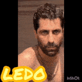 a man with a beard wearing a gold chain and a yellow sticker that says " ledo "