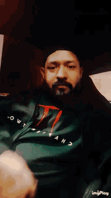 a man with a beard wearing a shirt that says " out " on it
