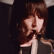 a close up of a man playing a saxophone in a dark room