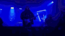 a blurry picture of a man playing a guitar on a stage .