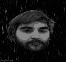 a black and white photo of a man 's head with a beard and nose ring .