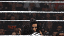 a wrestling match is being held in a ring with a referee in the background