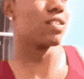 a close up of a woman 's face with a pink tank top on