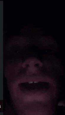 a man 's face is visible in the dark