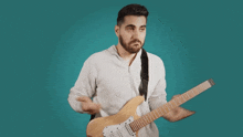 a man with a beard is holding a guitar in his right hand