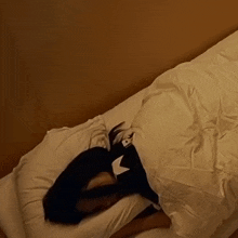 a woman laying on a bed with a white comforter