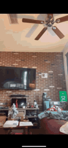 a living room with a tv and a ceiling fan